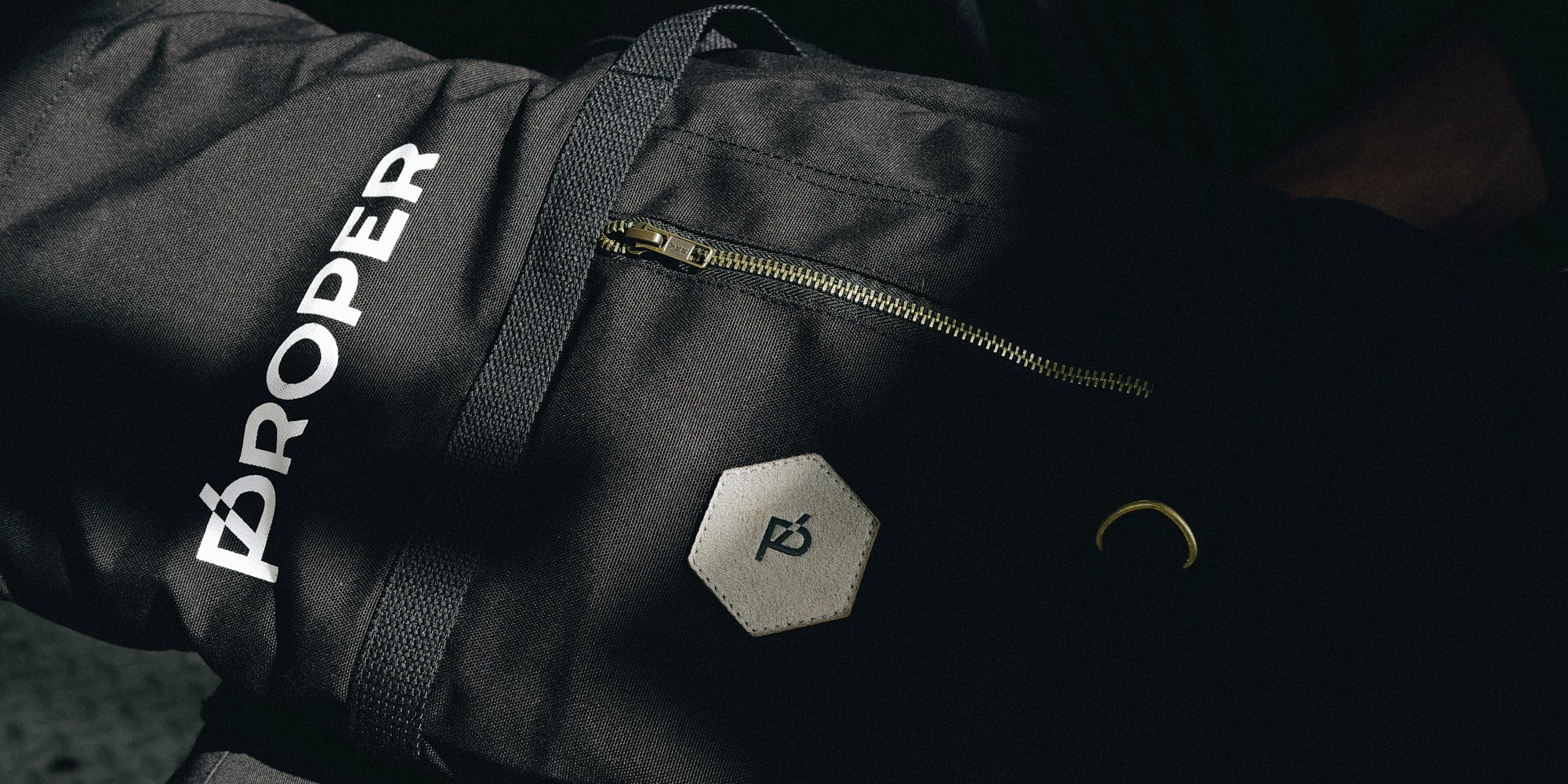 Black bag with 'Proper' branding on a dark background